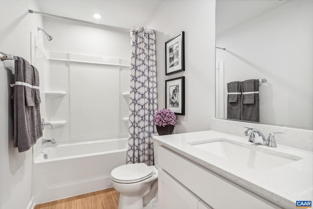 bathroom featuring toilet, shower / tub combo with curtain, vanity, and wood finished floors