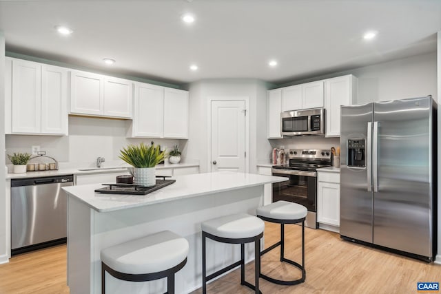 kitchen with white cabinets, a breakfast bar area, and stainless steel appliances