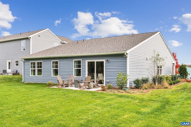 back of house featuring a yard, a patio area, and a shingled roof