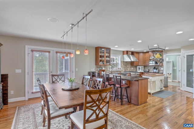 dining area featuring healthy amount of natural light, light wood-type flooring, baseboards, and recessed lighting