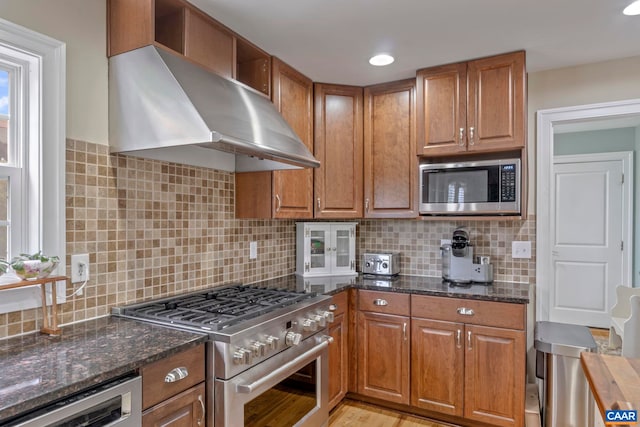 kitchen featuring stainless steel appliances, extractor fan, and brown cabinets