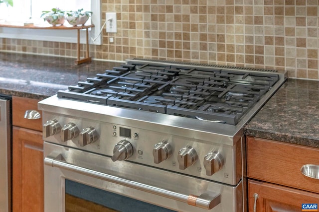 kitchen view of high end range, backsplash, and brown cabinetry