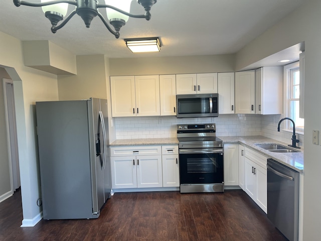 kitchen featuring sink, stainless steel appliances, light stone countertops, white cabinets, and dark hardwood / wood-style flooring