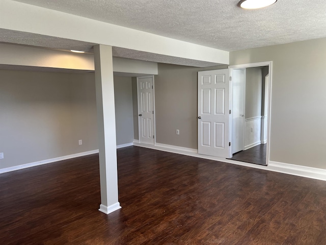 basement featuring dark hardwood / wood-style floors and a textured ceiling