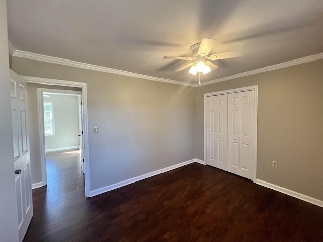 unfurnished bedroom featuring a closet, crown molding, dark hardwood / wood-style floors, and ceiling fan