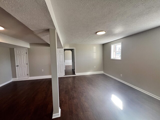 basement with dark wood-type flooring and a textured ceiling