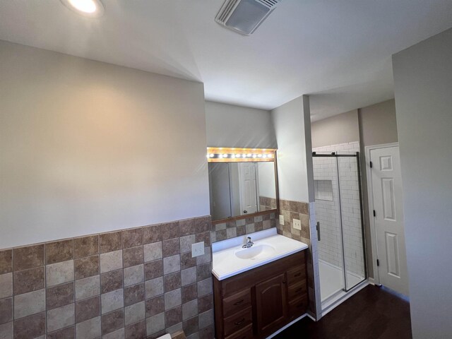 bathroom featuring vanity, tile walls, and an enclosed shower