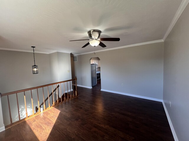 empty room with crown molding, dark hardwood / wood-style floors, and ceiling fan