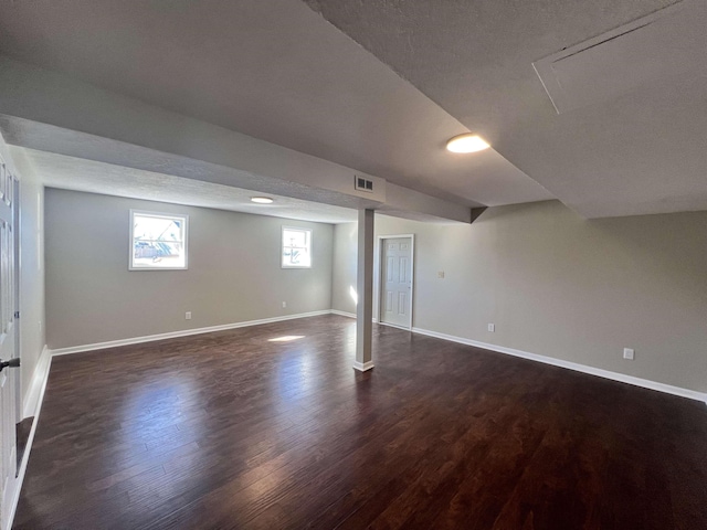 basement with dark hardwood / wood-style floors