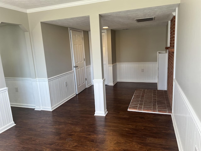 empty room with dark hardwood / wood-style floors and a textured ceiling