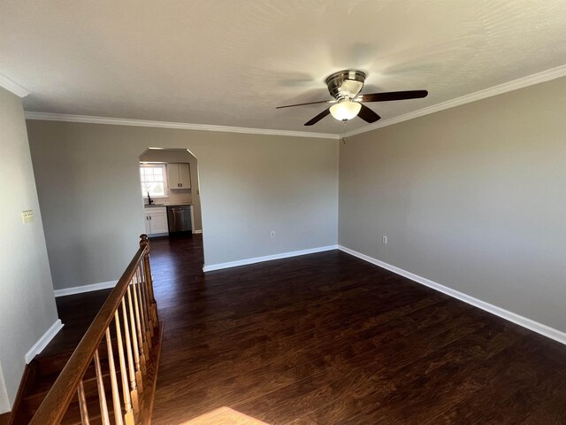 empty room with sink, crown molding, dark wood-type flooring, and ceiling fan