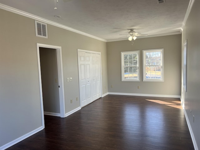 unfurnished bedroom featuring ornamental molding, dark hardwood / wood-style floors, a textured ceiling, and ceiling fan