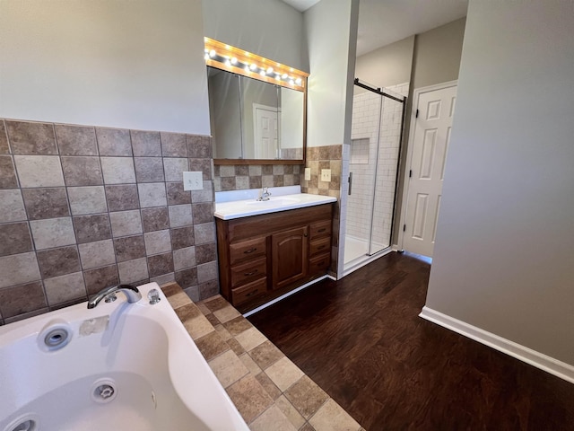 bathroom with tile walls, vanity, wood-type flooring, and separate shower and tub