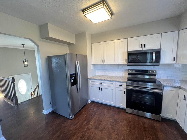 kitchen with stainless steel appliances, light stone countertops, dark wood-type flooring, and white cabinets