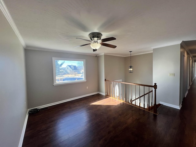 spare room featuring dark hardwood / wood-style flooring, ornamental molding, and ceiling fan