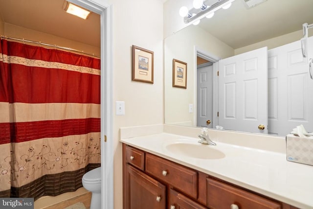 bathroom with toilet, vanity, and walk in shower