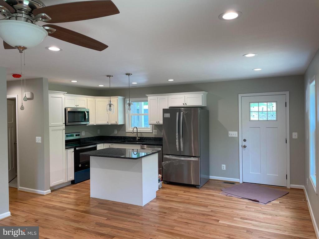  - kitchen with stainless steel appliances, a sink, dark countertops, white cabinetry, and recessed lighting