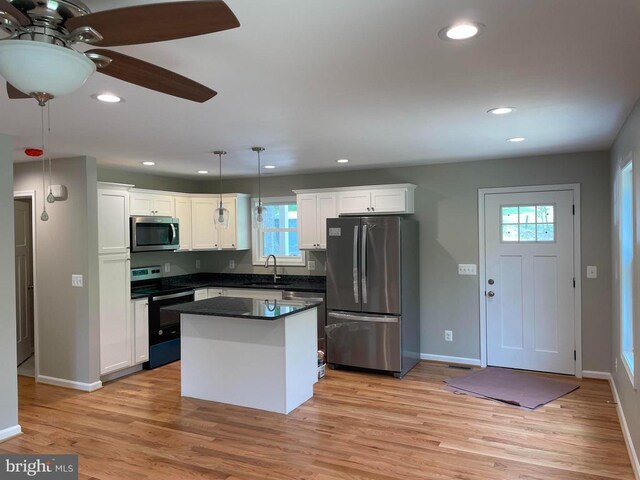  - kitchen with stainless steel appliances, a sink, dark countertops, white cabinetry, and recessed lighting
