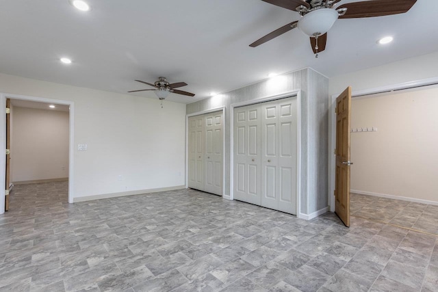 unfurnished bedroom featuring multiple closets and ceiling fan