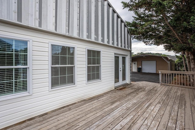 wooden terrace featuring a garage and an outdoor structure