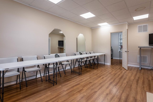 dining area with hardwood / wood-style flooring and a paneled ceiling