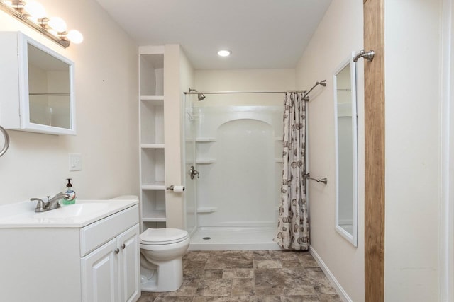 bathroom featuring vanity, toilet, and walk in shower