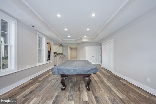 playroom featuring hardwood / wood-style flooring, pool table, a tray ceiling, and crown molding