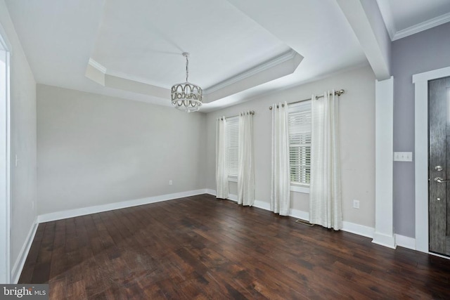 spare room featuring dark wood-type flooring, ornamental molding, and a tray ceiling