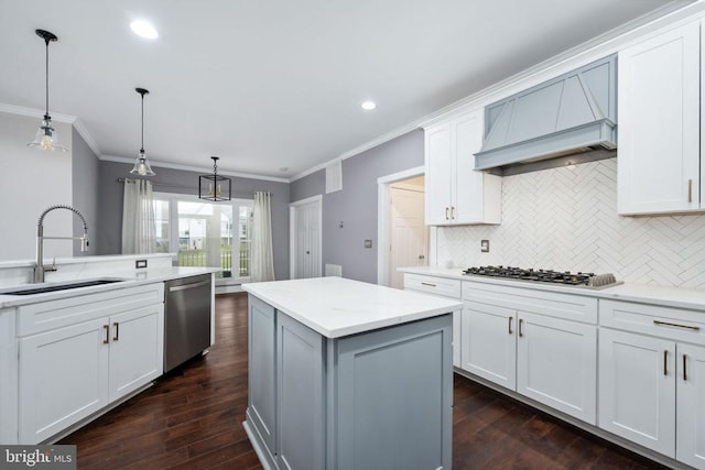 kitchen featuring appliances with stainless steel finishes, a center island, sink, and white cabinets