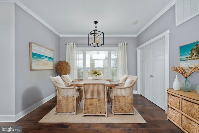 dining area featuring ornamental molding, a notable chandelier, and dark hardwood / wood-style flooring