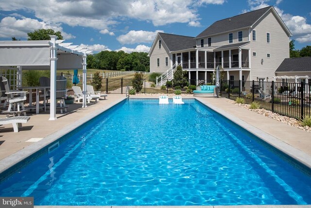 view of pool featuring a patio, a sunroom, and a pergola