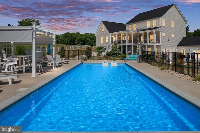 pool at dusk featuring a patio area