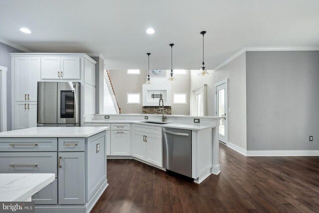 kitchen with stainless steel appliances, a kitchen island with sink, sink, and white cabinets