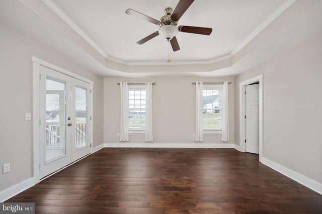 empty room featuring dark wood-type flooring, a raised ceiling, and french doors