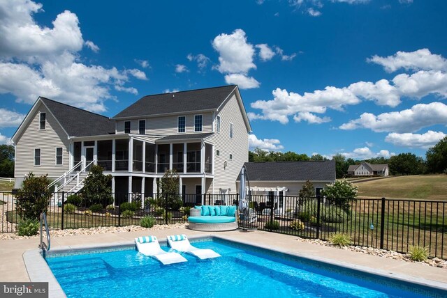 back of property with a fenced in pool and a sunroom