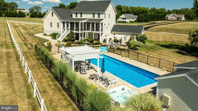 rear view of house with a patio, a pergola, a fenced in pool, and a sunroom