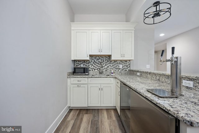 kitchen with hardwood / wood-style floors, tasteful backsplash, sink, white cabinets, and light stone counters