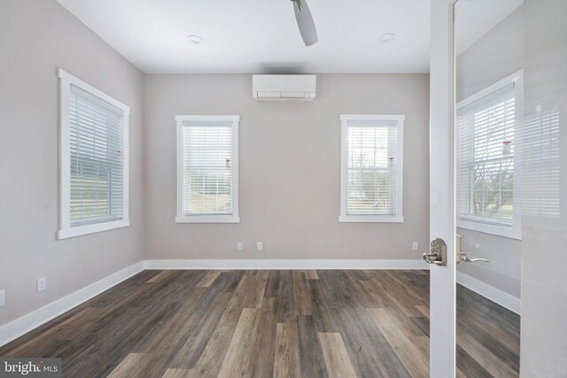 empty room featuring ceiling fan, dark hardwood / wood-style floors, and a wall mounted AC