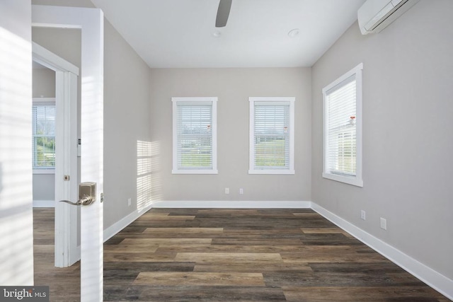 unfurnished room with a healthy amount of sunlight, dark hardwood / wood-style floors, and a wall mounted AC