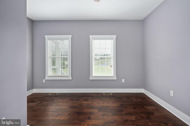 spare room featuring dark wood-type flooring