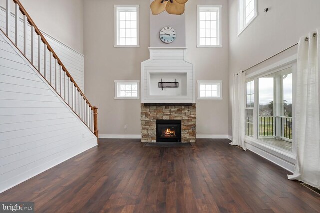 unfurnished living room with a fireplace, dark hardwood / wood-style flooring, and a high ceiling