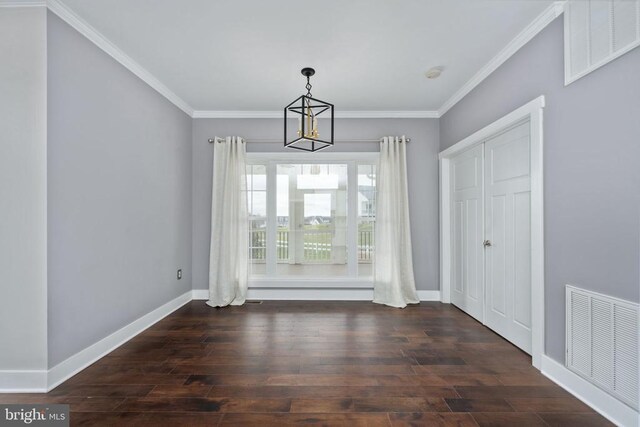 unfurnished dining area with ornamental molding, dark hardwood / wood-style floors, and a chandelier