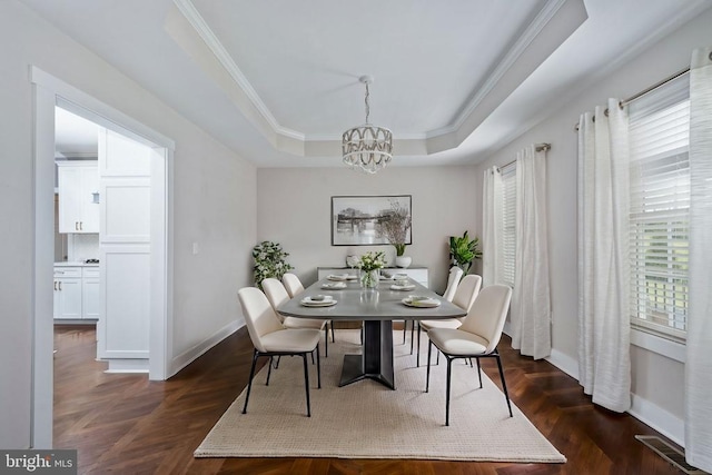 dining space with a chandelier, ornamental molding, a raised ceiling, and dark parquet flooring