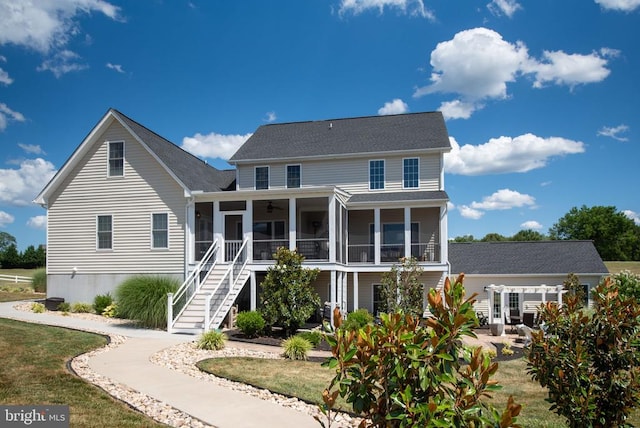 back of house with a yard, a pergola, and a sunroom