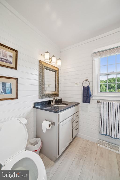 12014 Jefferson Hwy, Mineral, VA 23117 - half bathroom with wood finished floors, vanity, and crown molding