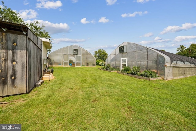 12014 Jefferson Hwy, Mineral, VA 23117 - view of grassy yard with a greenhouse, an outdoor structure, and a vegetable garden