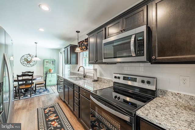 166 John Tucker Rd, Madison, VA 22727 - kitchen with stainless steel appliances, a sink, dark brown cabinets, light wood-type flooring, and light stone counters