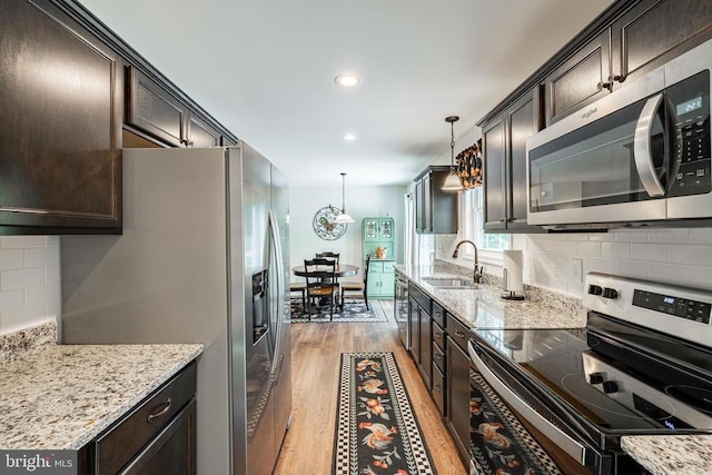 166 John Tucker Rd, Madison, VA 22727 - kitchen featuring stainless steel appliances, a sink, light wood-type flooring, dark brown cabinets, and decorative backsplash