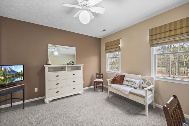living area featuring ceiling fan, carpet flooring, baseboards, and visible vents
