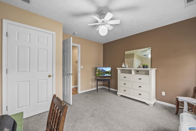 carpeted bedroom with a textured ceiling, visible vents, baseboards, and a ceiling fan
